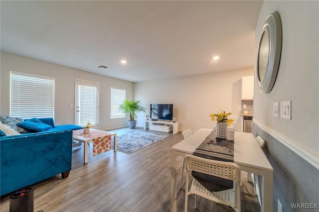 living room featuring recessed lighting, baseboards, visible vents, and light wood finished floors