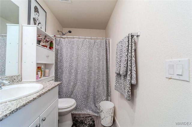 full bath with toilet, curtained shower, and vanity