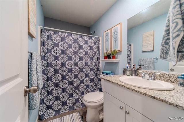 full bathroom featuring a shower with shower curtain, vanity, and toilet