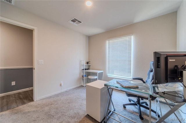 office area featuring light carpet, baseboards, and visible vents