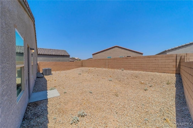 view of yard with a fenced backyard and central air condition unit