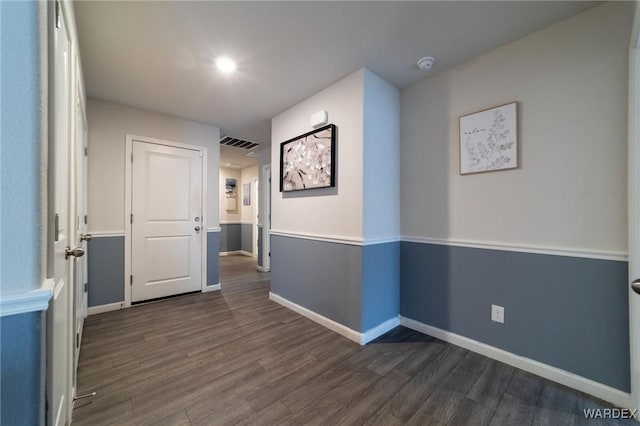 interior space featuring baseboards, visible vents, and dark wood finished floors