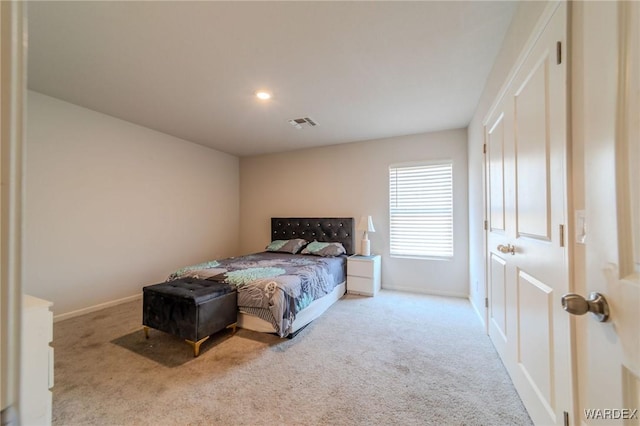 bedroom with baseboards, visible vents, and light colored carpet