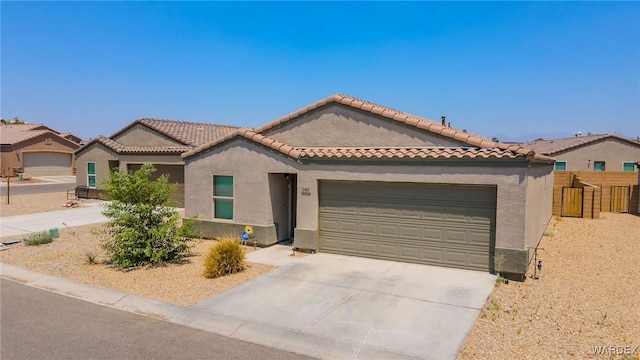 mediterranean / spanish-style house featuring a garage, driveway, a tile roof, and stucco siding