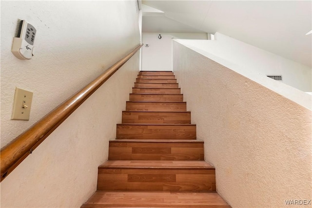 stairs with visible vents and a textured wall