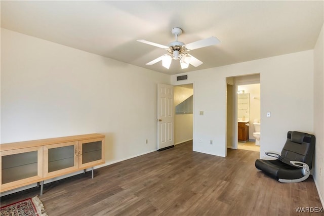 living area featuring dark wood-style floors, baseboards, visible vents, and a ceiling fan