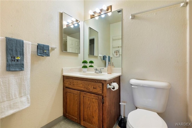 bathroom with visible vents, vanity, and toilet