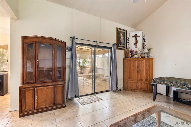 interior space featuring light tile patterned floors and high vaulted ceiling