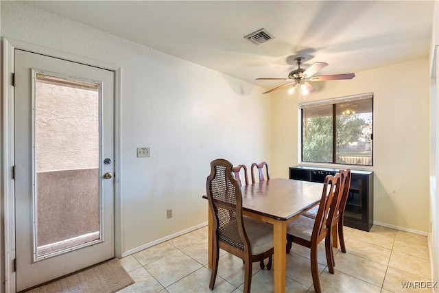 dining room with light tile patterned floors, a ceiling fan, visible vents, and baseboards