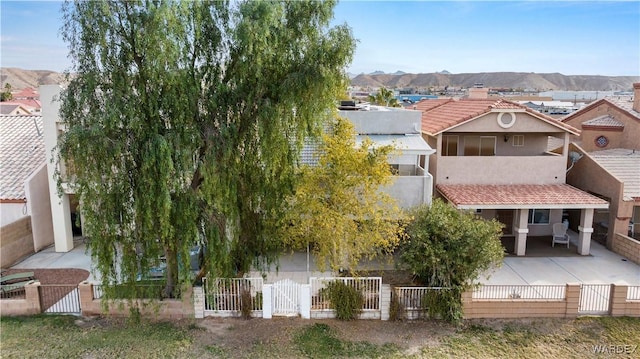 view of front of property featuring a fenced front yard, a gate, a mountain view, and stucco siding