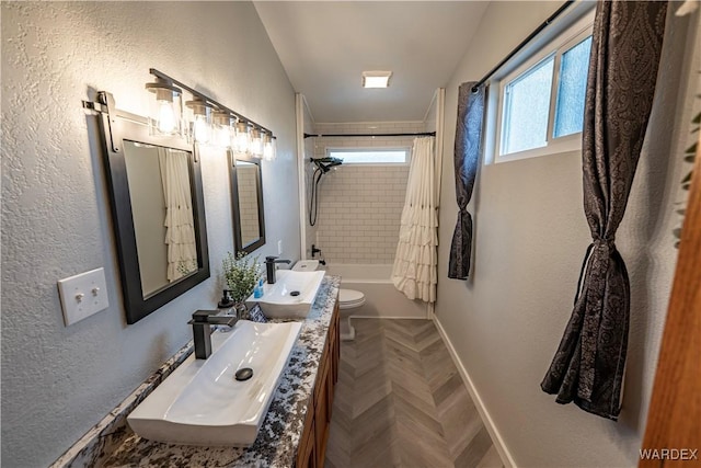 full bathroom with baseboards, a textured wall, toilet, shower / bath combo with shower curtain, and vanity