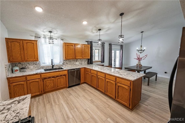 kitchen featuring backsplash, brown cabinetry, a sink, dishwasher, and a peninsula