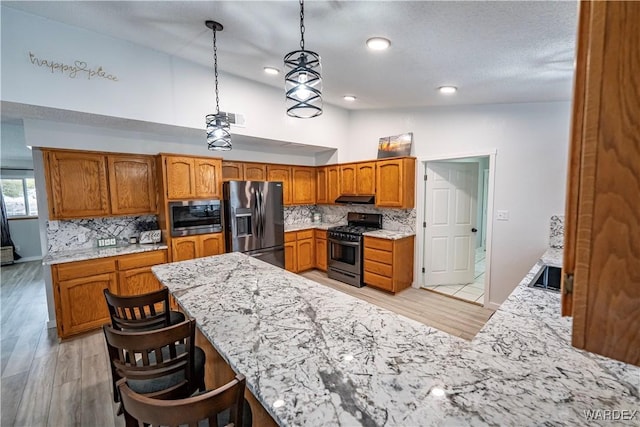 kitchen featuring lofted ceiling, visible vents, appliances with stainless steel finishes, and backsplash