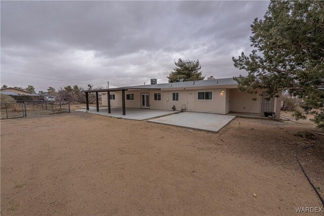 back of house featuring a patio area, fence, and stucco siding