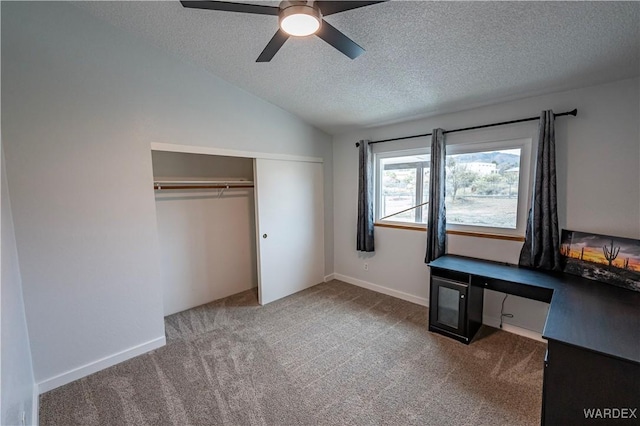 interior space featuring lofted ceiling, a textured ceiling, ceiling fan, carpet floors, and a closet