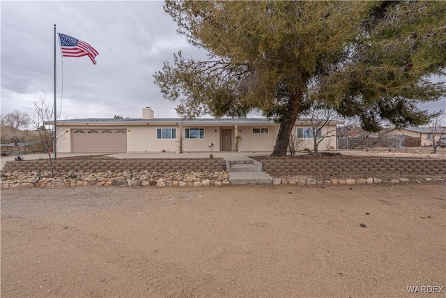 ranch-style home featuring an attached garage and fence