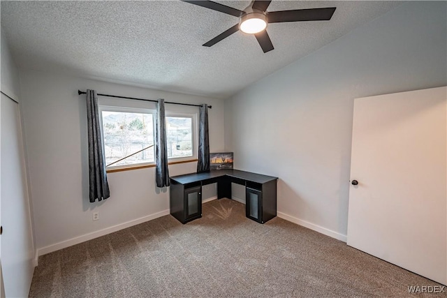 unfurnished office with carpet floors, baseboards, a textured ceiling, and lofted ceiling