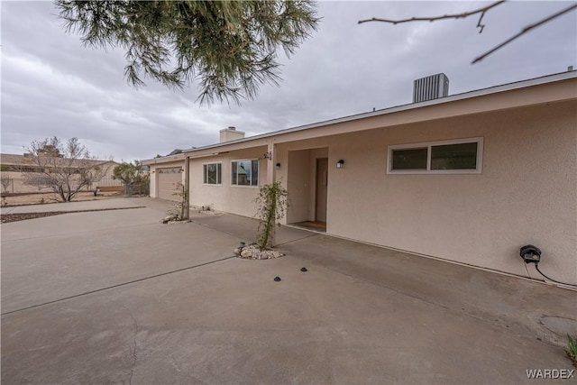 view of front of home with driveway, an attached garage, and stucco siding