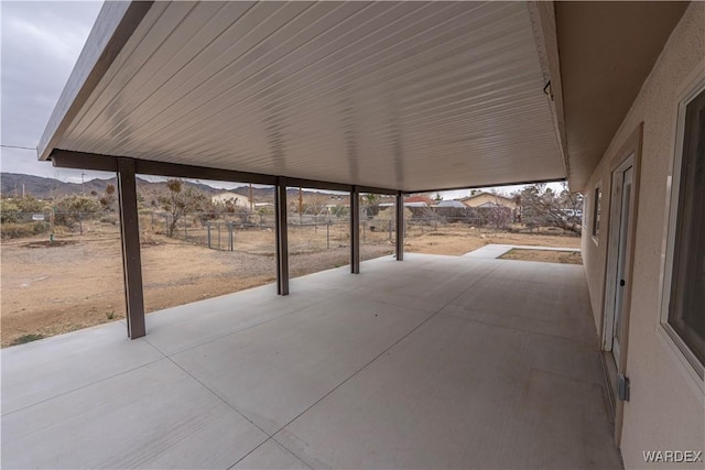 view of patio with fence and a mountain view