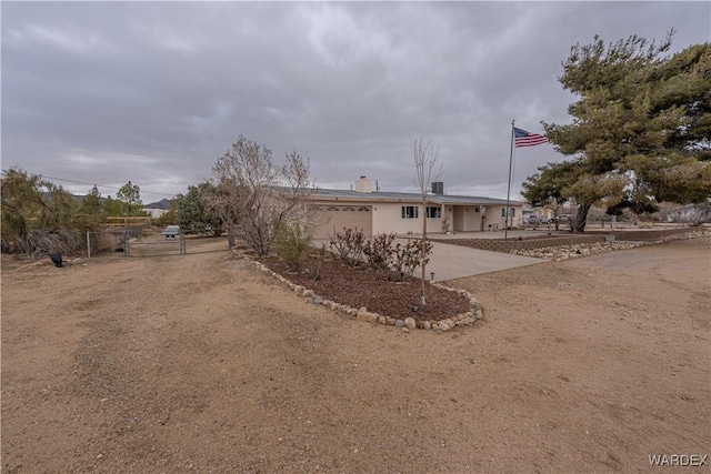 view of front of house featuring driveway, an attached garage, fence, and stucco siding