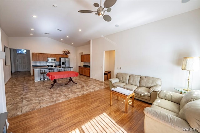 living room with visible vents, ceiling fan, high vaulted ceiling, recessed lighting, and light wood finished floors