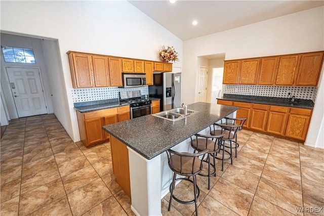 kitchen with a sink, stainless steel microwave, fridge with ice dispenser, backsplash, and range with gas cooktop