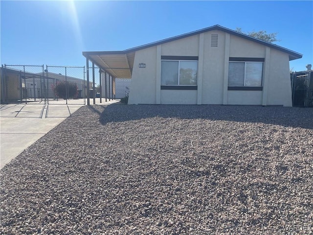 back of house with an attached carport and fence