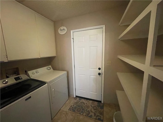 clothes washing area featuring cabinet space, separate washer and dryer, and a textured ceiling