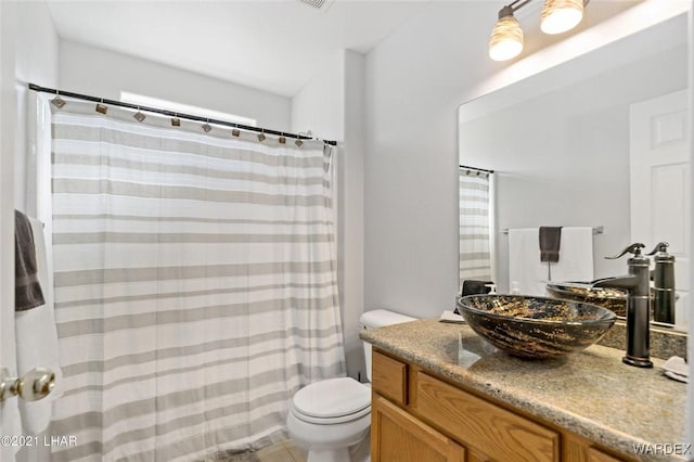 full bathroom featuring curtained shower, vanity, and toilet