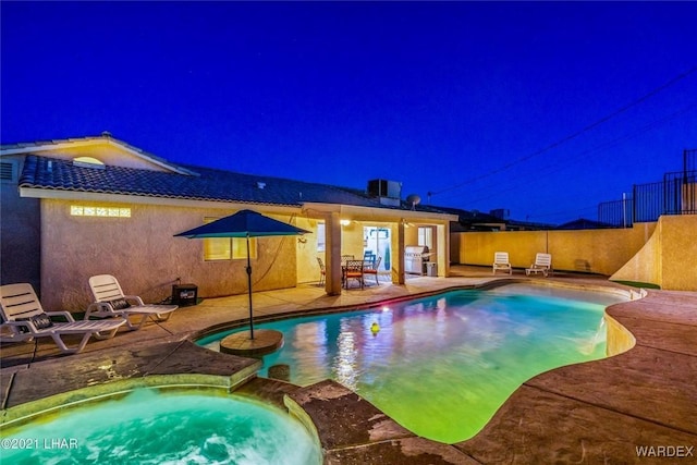 view of swimming pool with a patio area, a pool with connected hot tub, fence, and area for grilling