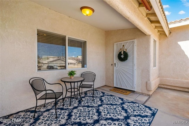 doorway to property featuring a patio and stucco siding