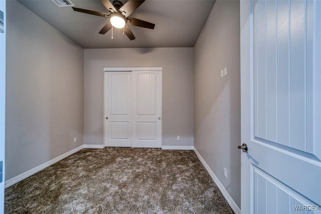 unfurnished bedroom featuring carpet floors, a closet, baseboards, and a ceiling fan