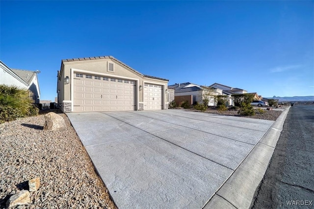 single story home with a garage, concrete driveway, and stucco siding