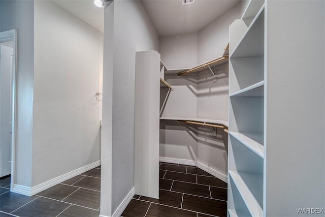 spacious closet featuring wood tiled floor and built in desk