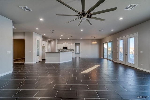 unfurnished living room featuring baseboards, visible vents, and recessed lighting