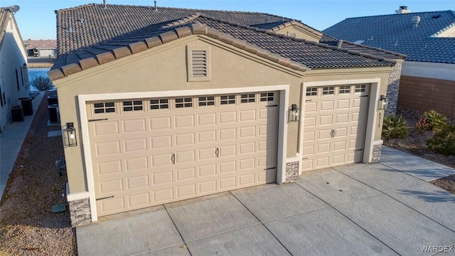 garage featuring driveway and cooling unit