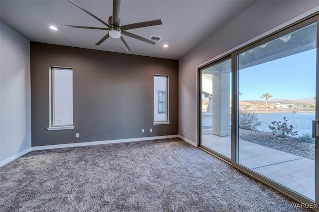 carpeted empty room with visible vents, baseboards, ceiling fan, a water view, and recessed lighting