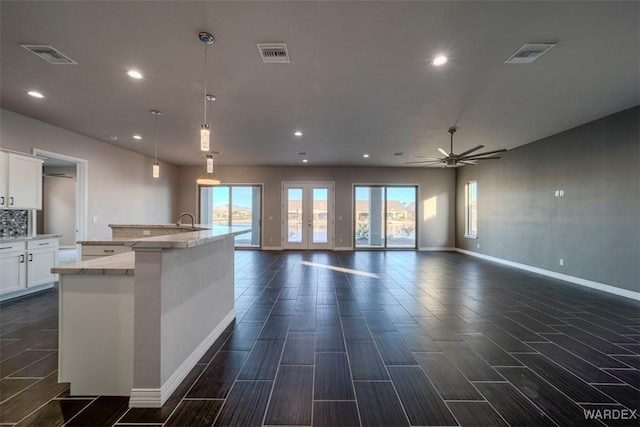 kitchen featuring open floor plan, hanging light fixtures, visible vents, and white cabinetry