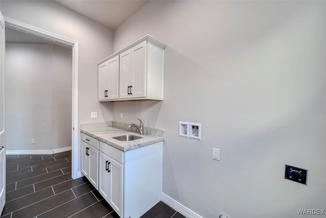 clothes washing area with cabinet space, wood tiled floor, hookup for an electric dryer, washer hookup, and a sink