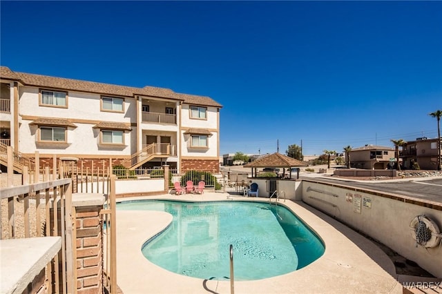 pool featuring fence and a gazebo