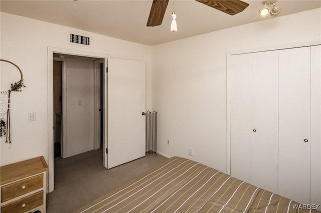 unfurnished bedroom with a closet, carpet flooring, visible vents, and a ceiling fan