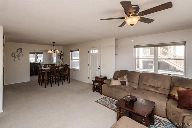 living area with carpet and ceiling fan with notable chandelier