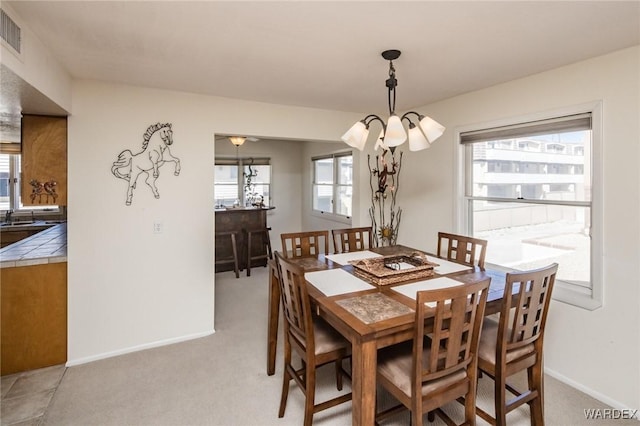 dining space featuring light carpet, visible vents, and baseboards