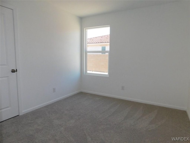 carpeted empty room with baseboards