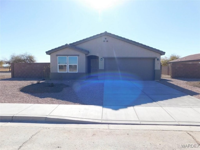 view of front of house featuring concrete driveway, a tiled roof, an attached garage, and stucco siding