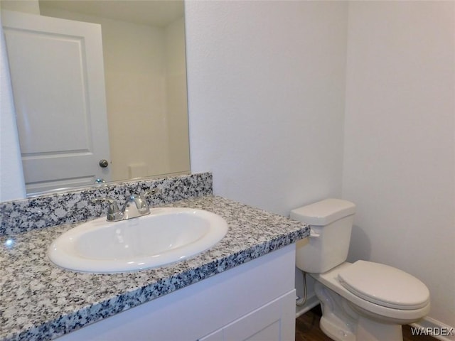 half bathroom featuring toilet and vanity