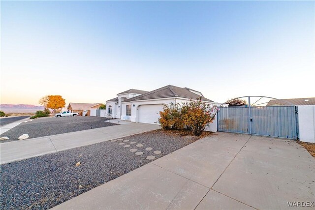 view of front of home featuring an attached garage, a gate, and concrete driveway