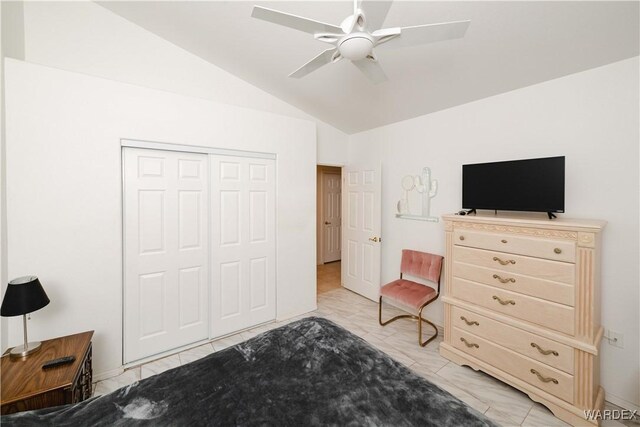 bedroom with marble finish floor, ceiling fan, vaulted ceiling, and a closet