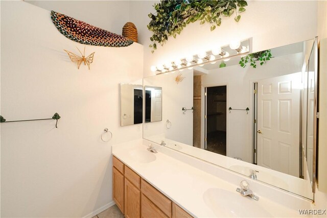 bathroom with double vanity, a sink, and baseboards