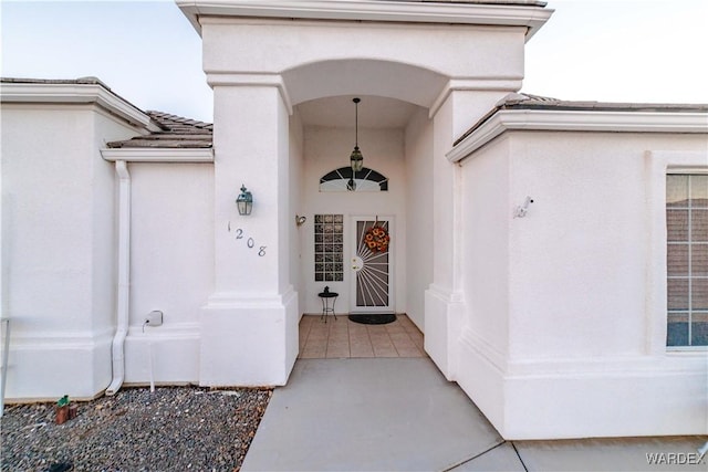 property entrance featuring a tiled roof and stucco siding